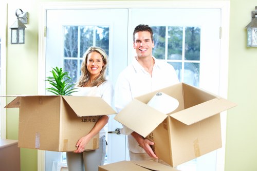 Professional movers carrying furniture through a Kensington property entrance