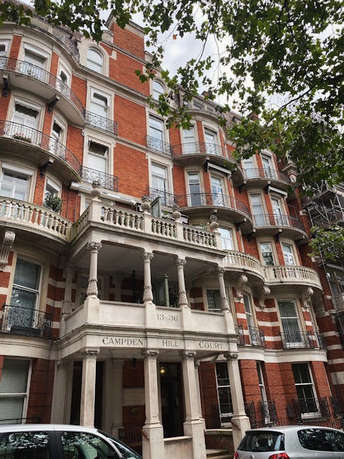 A rectangular white metal sign mounted on a red brick wall displaying the text 'WELCOME TO SOUTH KENSINGTON SW7' with 'South Kensington' written in large black capital letters, 'WELCOME TO' and 'SW7' in smaller red fonts, indicating a street or area in London. The brick wall has a textured surface with visible mortar joints and a slightly weathered appearance. The sign is positioned centrally on the wall, which provides a stable backdrop for depicting a typical London residential or commercial area. This image may be relevant to house removals or local property services, highlighting the environment where packing, furniture transport, and home relocation activities by Kensington Man and Van could typically occur.